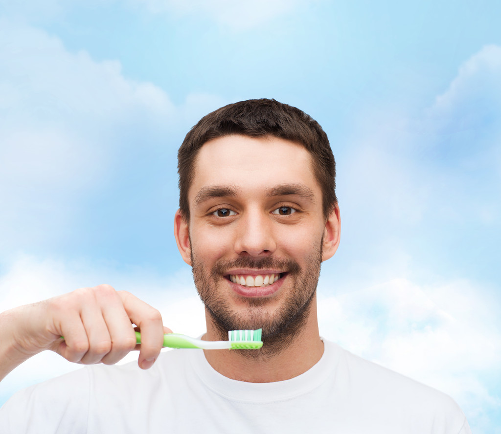 Jovem sorridente com escova de dentes
 - Foto, Imagem