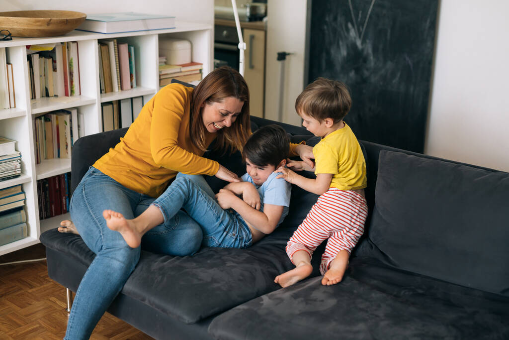 мать обнимает и играет с детьми дома - Фото, изображение