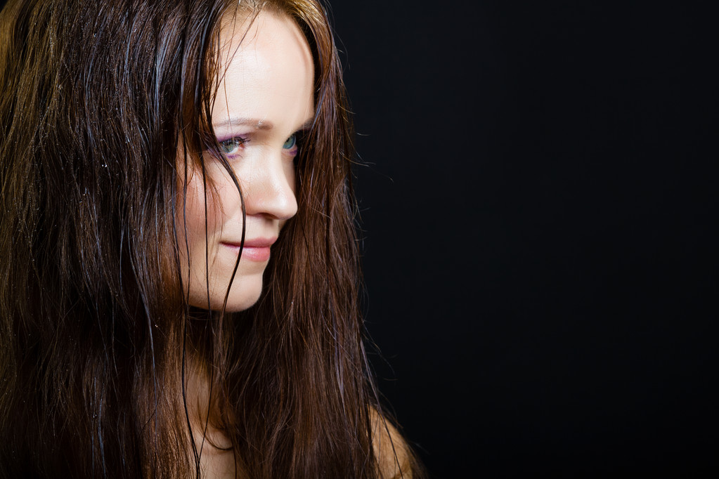 портрет молодої дівчини з довгим вологим волоссям на чорному
 - Фото, зображення