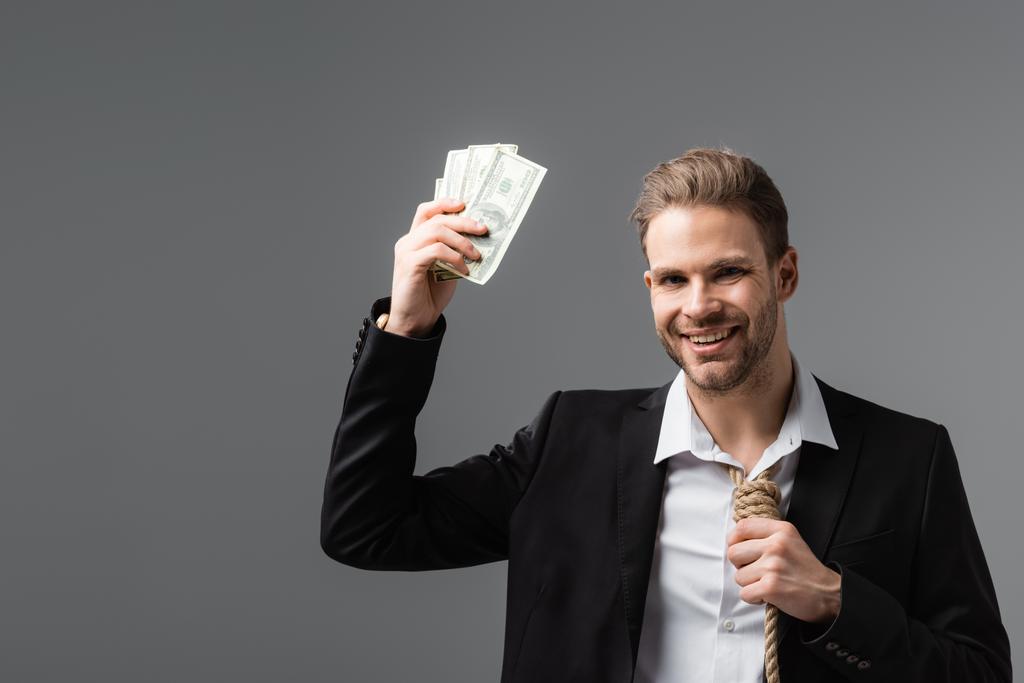 fröhlicher Geschäftsmann mit Strick statt Krawatte, der Dollar isoliert auf grau hält - Foto, Bild