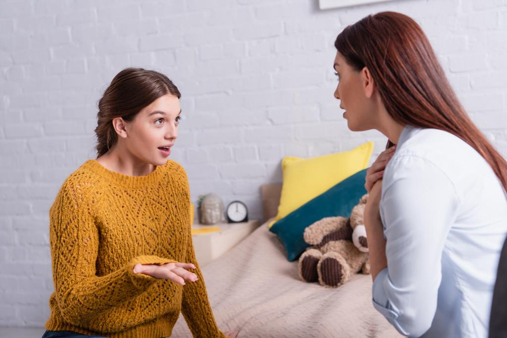 hija adolescente gesticulando mientras habla con la madre preocupada - Foto, Imagen
