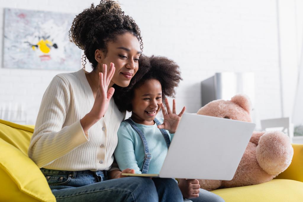 sonriente africano americano mamá y niño agitando las manos durante el chat de vídeo en el ordenador portátil - Foto, imagen