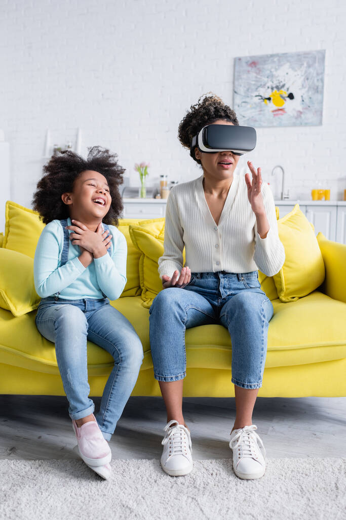 excited african american kid laughing near mother gesturing in vr headset - Photo, Image