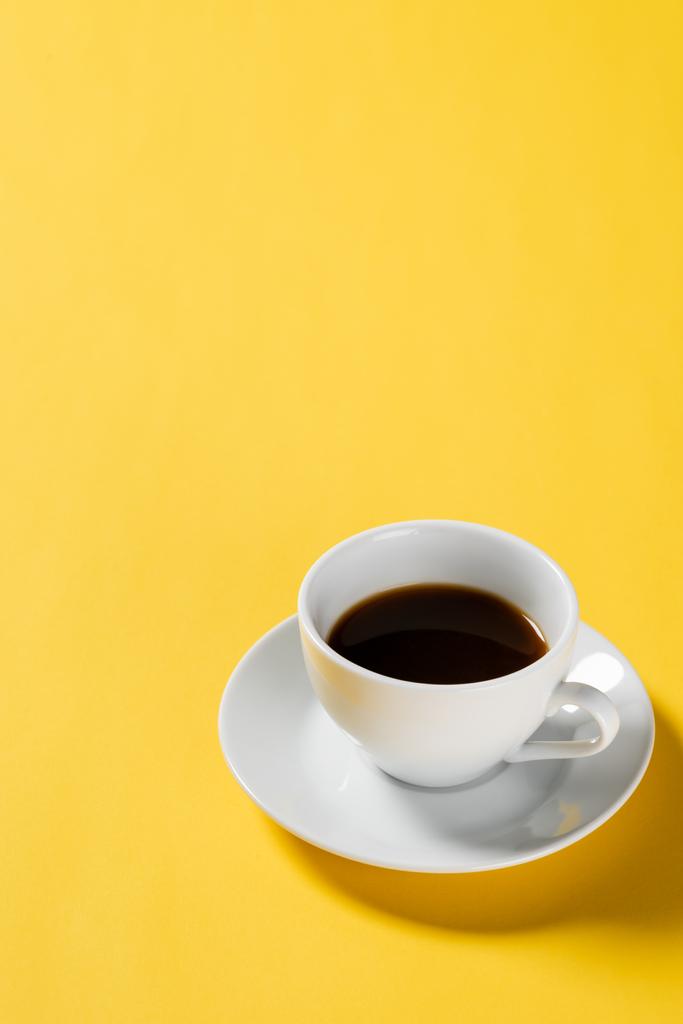 café negro en taza blanca sobre fondo amarillo  - Foto, Imagen