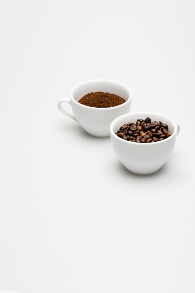 grains et café moulu dans des tasses sur blanc - Photo, image