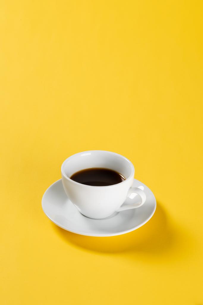黒コーヒー黄色の背景に白いマグカップ  - 写真・画像