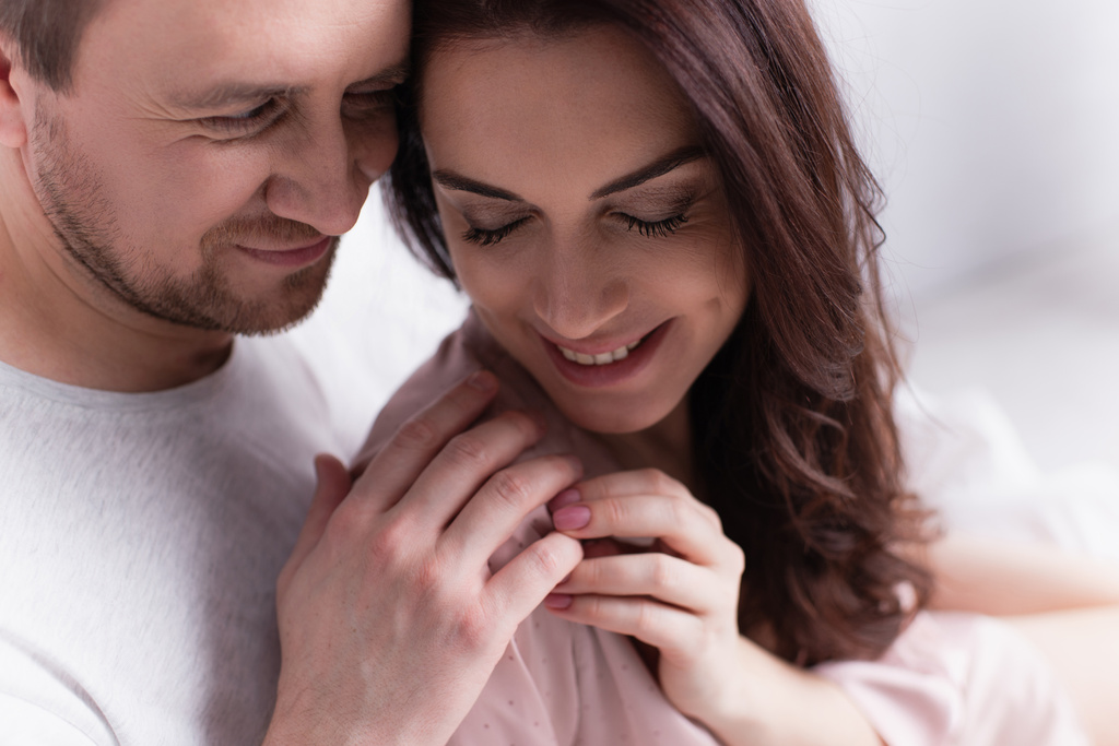 Smiling adult couple touching hands at home  - Photo, Image