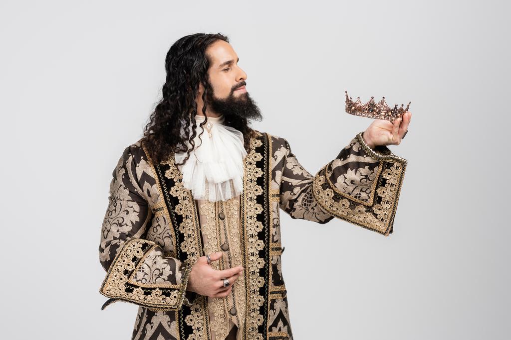 hispánský král ve středověkém oděvu držící zlatou korunu izolovanou na bílém - Fotografie, Obrázek