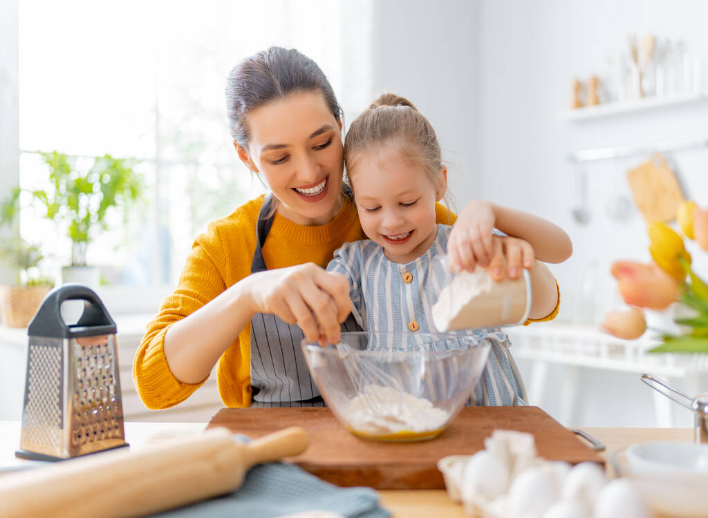 Šťastná milující rodina spolu připravuje pekárnu. Matka a dcera dcera dívka vaří sušenky a baví v kuchyni. Domácí jídlo a malý pomocník.     - Fotografie, Obrázek