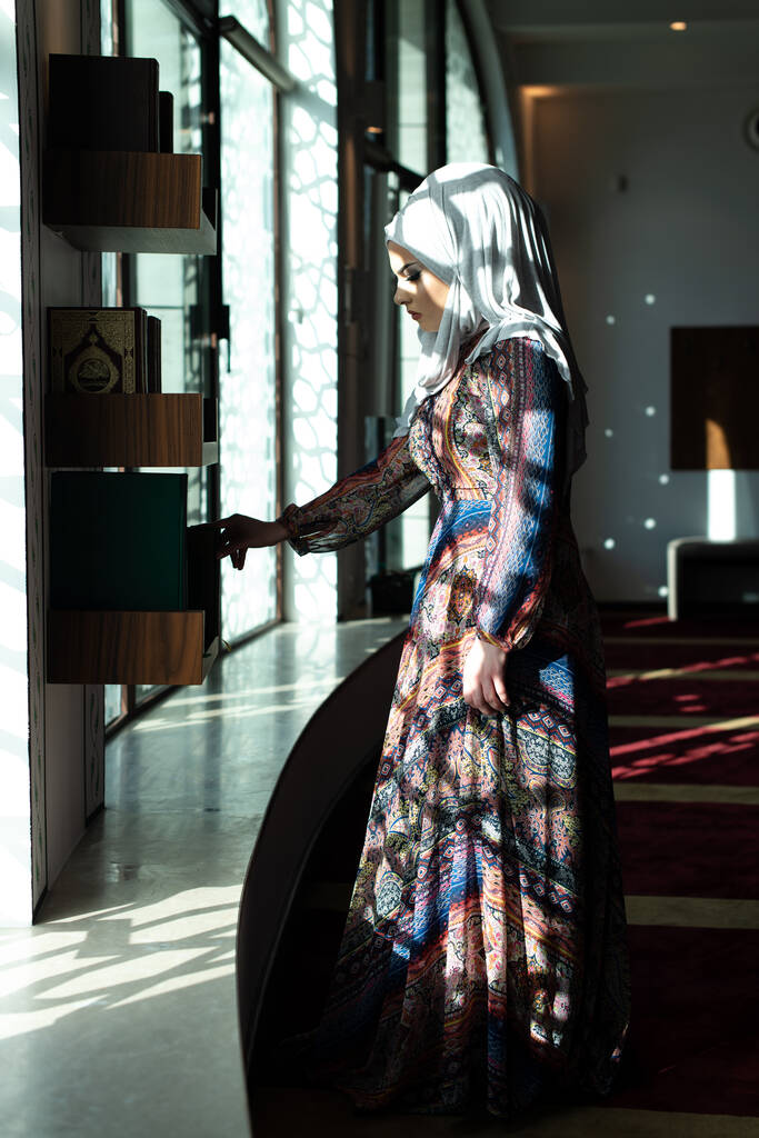 Mujer musulmana tomando el Corán o el Corán vestida con un vestido tradicional en la mezquita - Foto, imagen