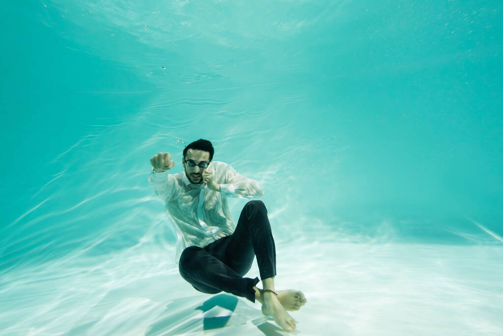 Empresário muçulmano em óculos falando no telefone celular na piscina  - Foto, Imagem