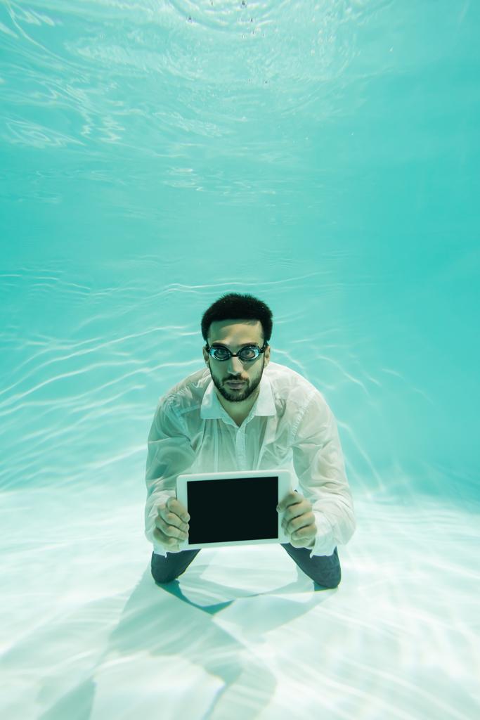 Arabský manažer v brýlích s digitálním tabletem pod vodou  - Fotografie, Obrázek