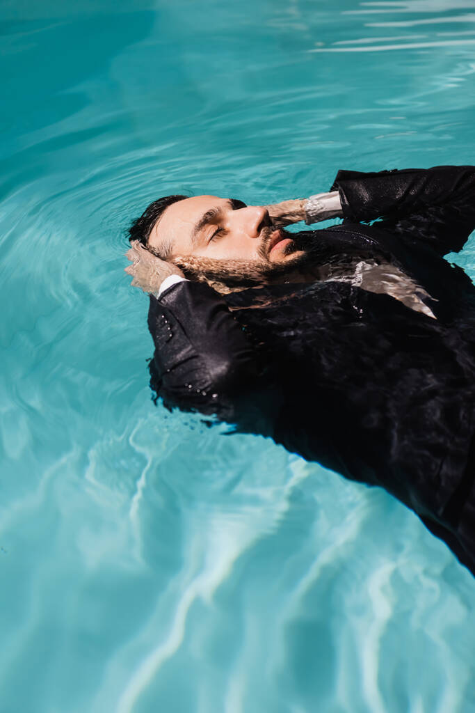 リップル水でプールで泳いで目を閉じたアラビアのビジネスマン  - 写真・画像