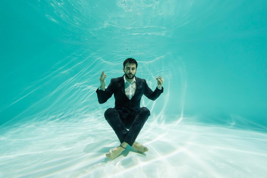 Homem de negócios árabe meditando na piscina  - Foto, Imagem