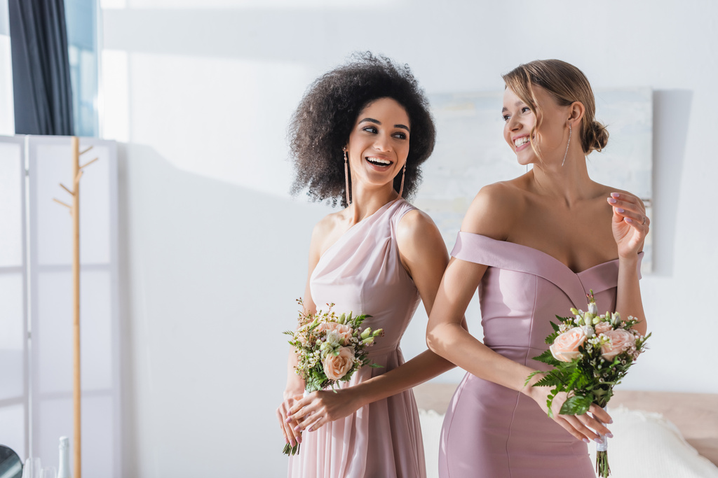 楽しい多文化の新婦付添人が寝室で結婚式の花束を持って - 写真・画像