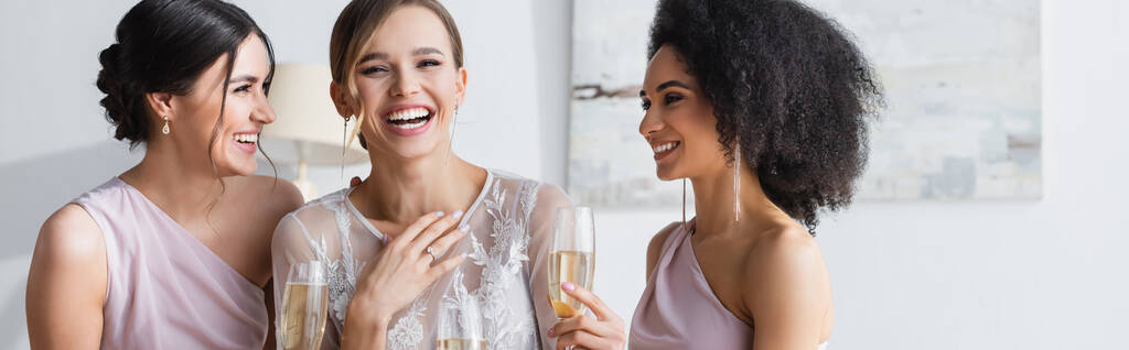 взволнованная невеста смеется рядом с друзьями, держа бокалы шампанского, баннер - Фото, изображение