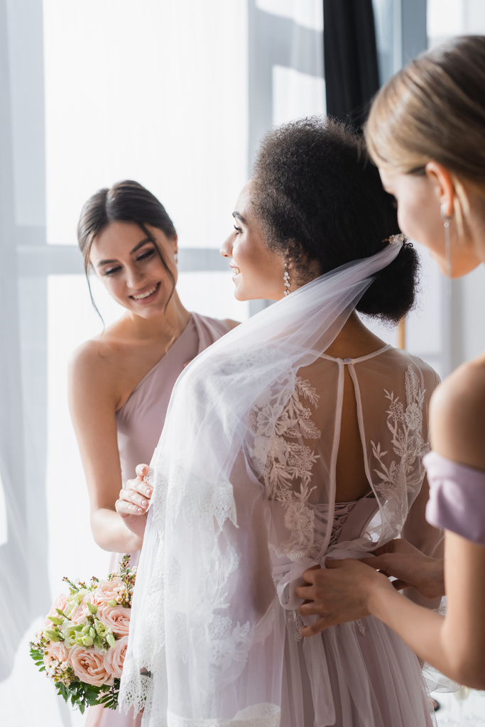 mosolygó koszorúslányok felkészítése afro-amerikai menyasszony esküvőre, elmosódott előtér - Fotó, kép
