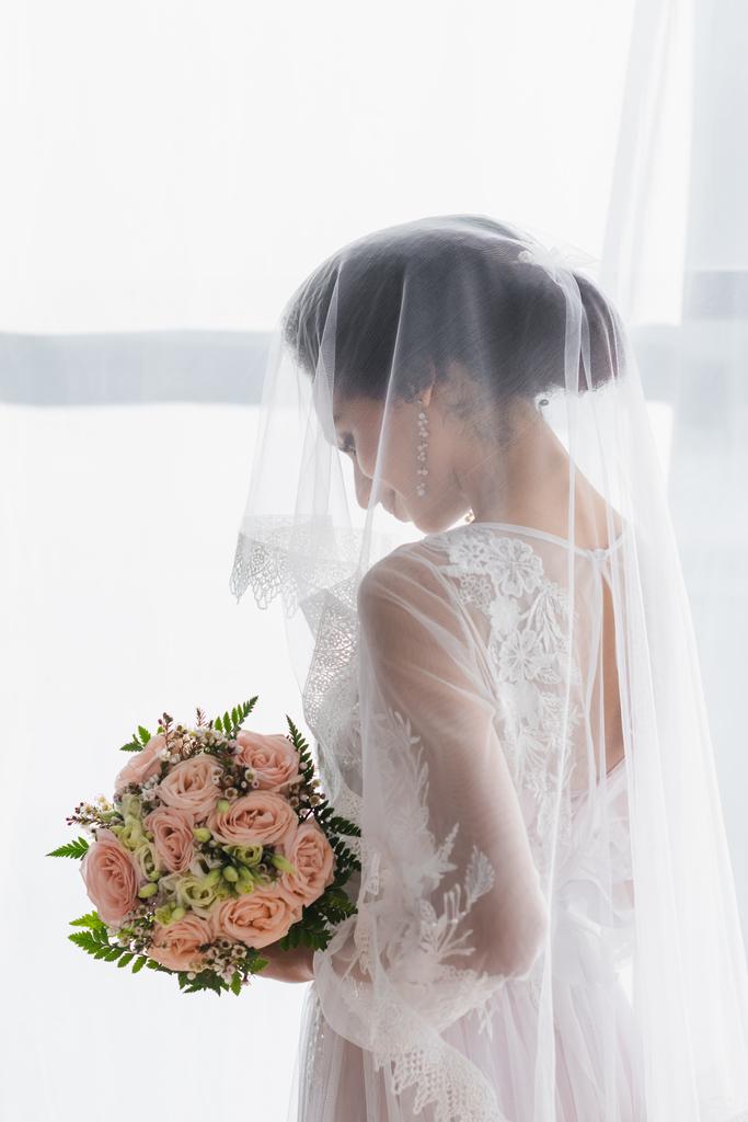 african american bride in veil holding wedding bouquet at home - Photo, Image