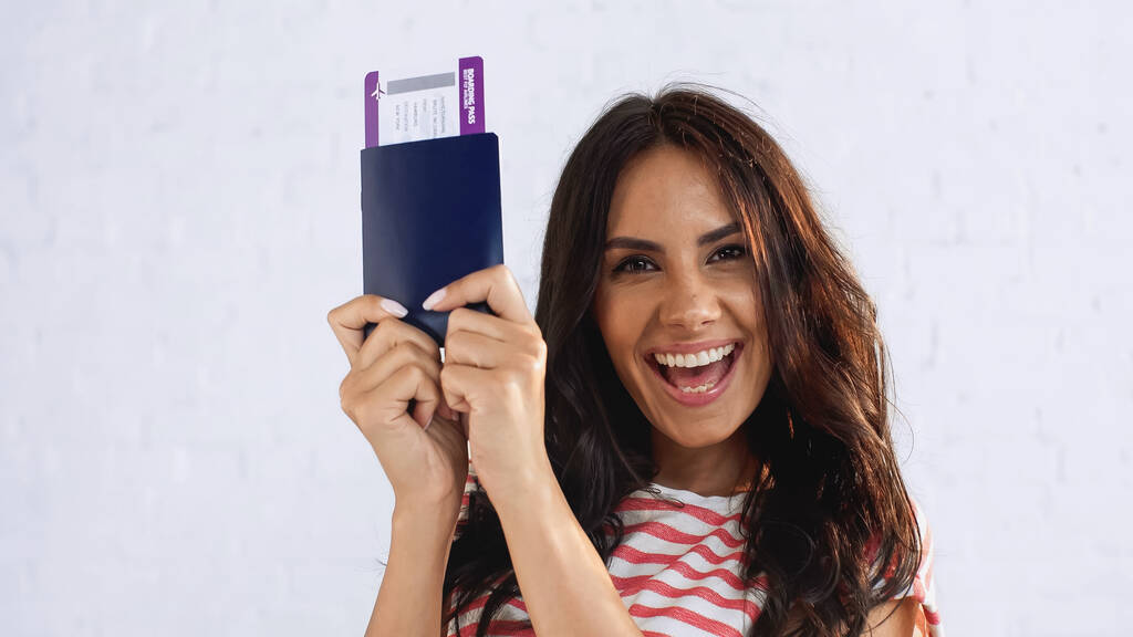 mulher animado segurando passaporte com bilhete de ar e olhando para a câmera - Foto, Imagem