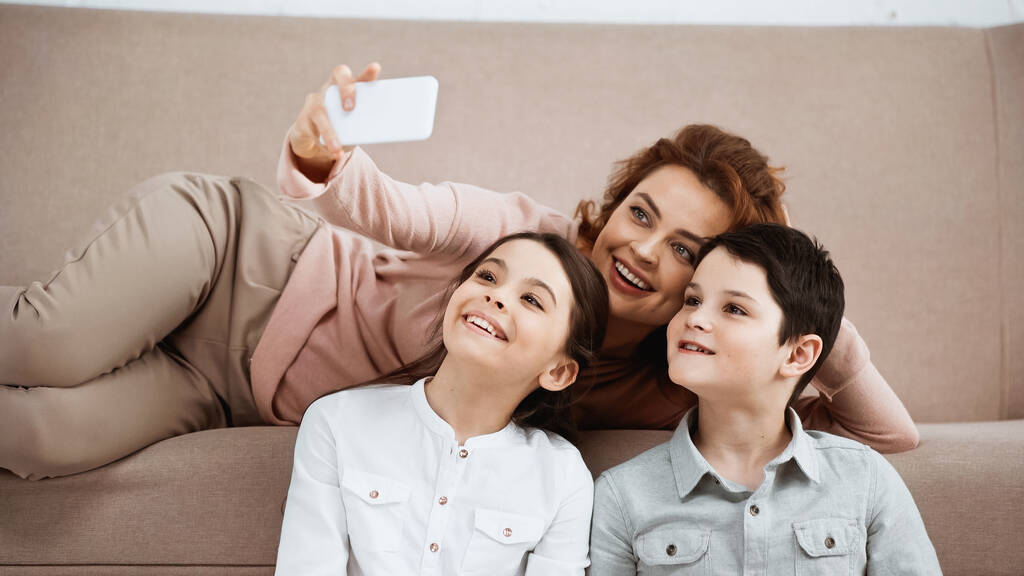Sorrindo mãe tomando selfie com crianças em casa  - Foto, Imagem