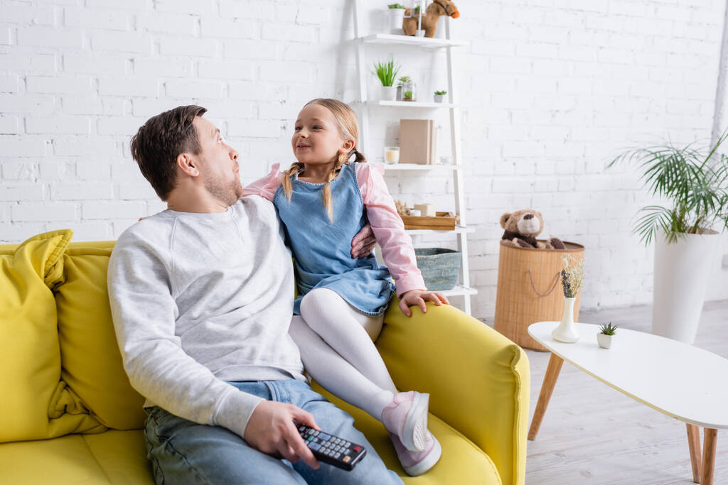 asombrados padre e hija mirándose mientras veían películas en casa - Foto, imagen