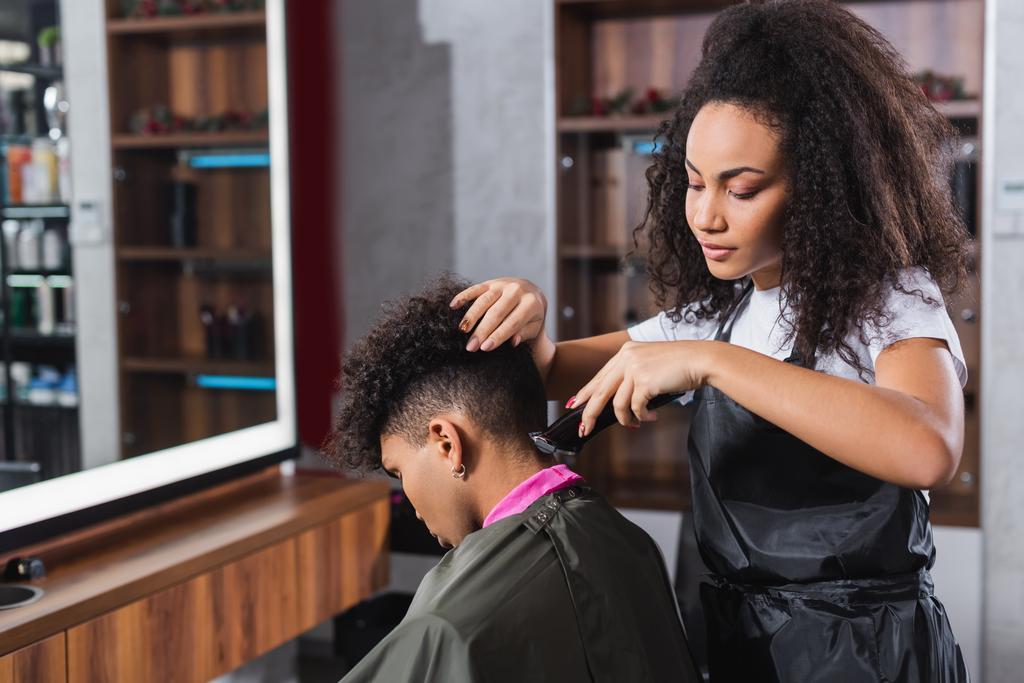 Африканський американець перукаря стриже шию клієнта в плащ і комір паперу  - Фото, зображення