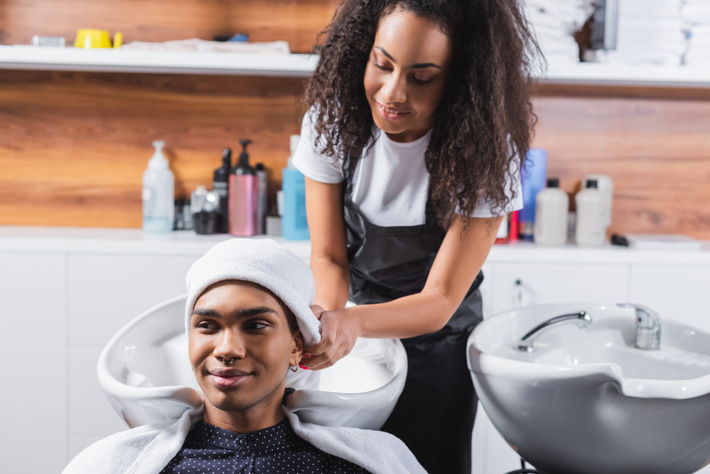 アフリカ系アメリカ人の美容師乾燥髪の笑顔男とタオル  - 写真・画像