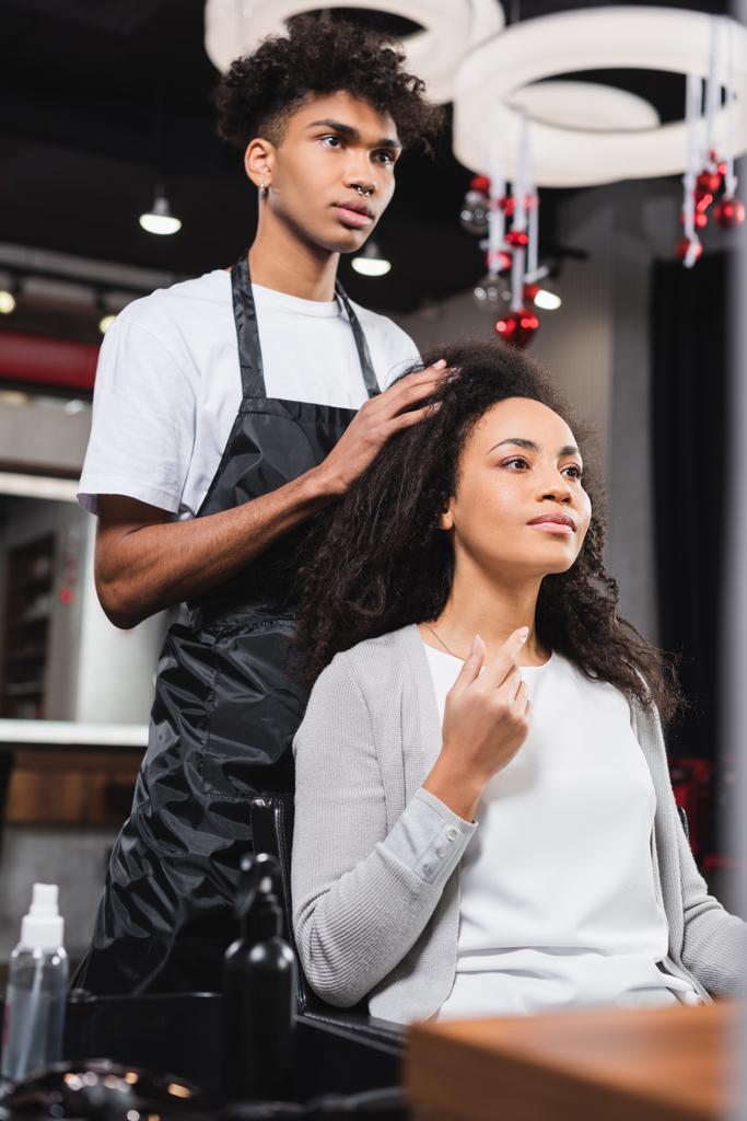 Afroamerykanka kobieta pokazuje długość do fryzjera w salonie  - Zdjęcie, obraz