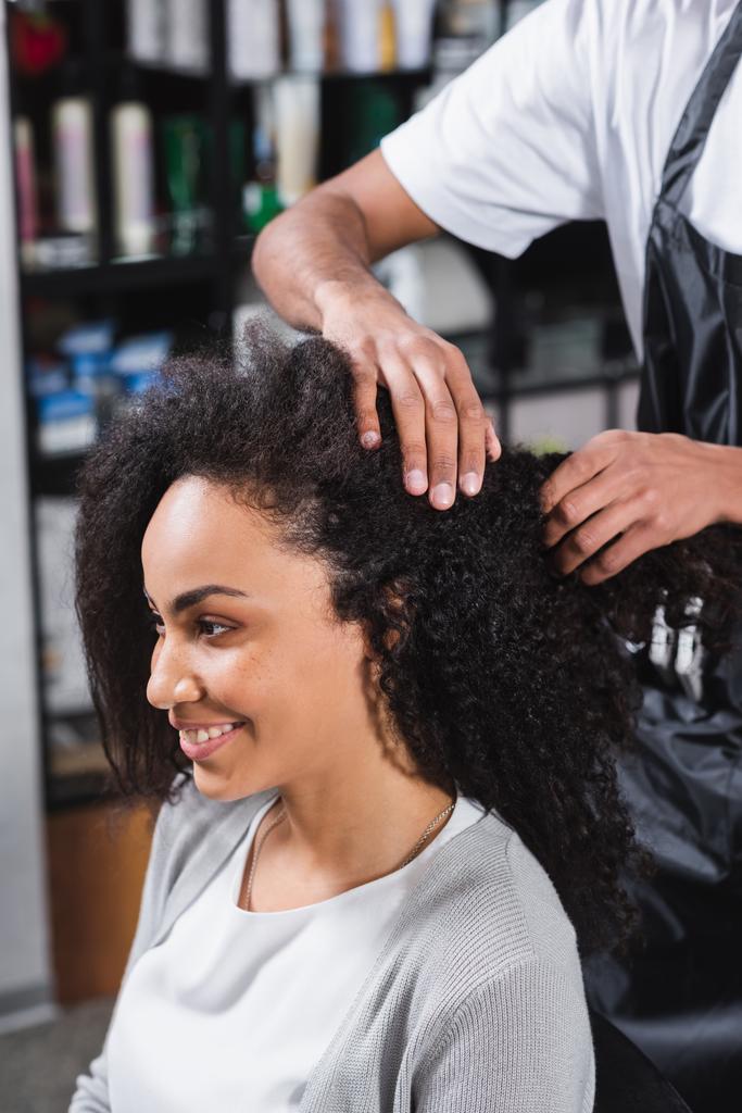 Веселая американка из Африки, сидящая возле парикмахерской в салоне  - Фото, изображение