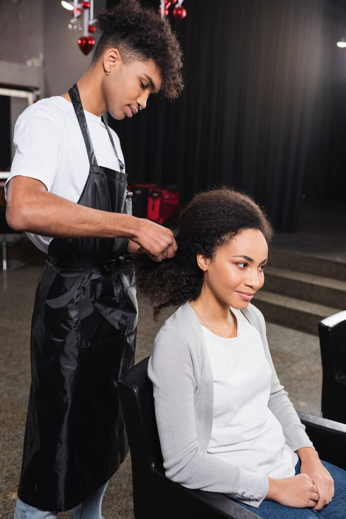 Afrikkalainen amerikkalainen kampaaja kudonta hiukset asiakkaan salonki  - Valokuva, kuva