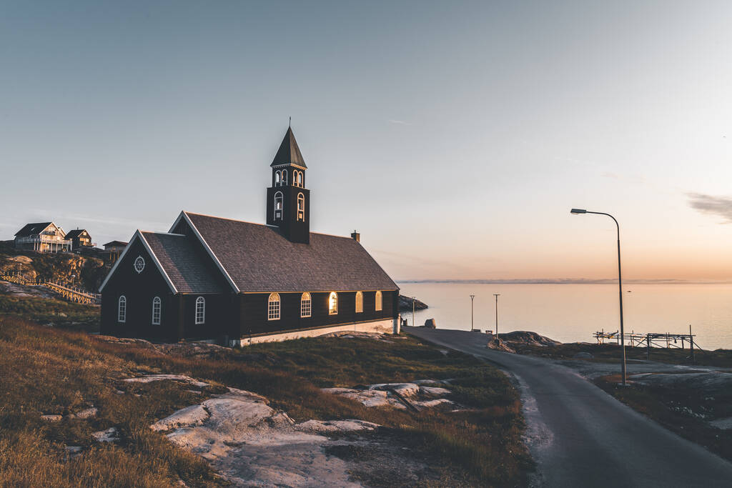 北グリーンランドの真夜中の太陽の光と青い空とイルリサットの北極都市の古い木製のシオン教会 - 写真・画像