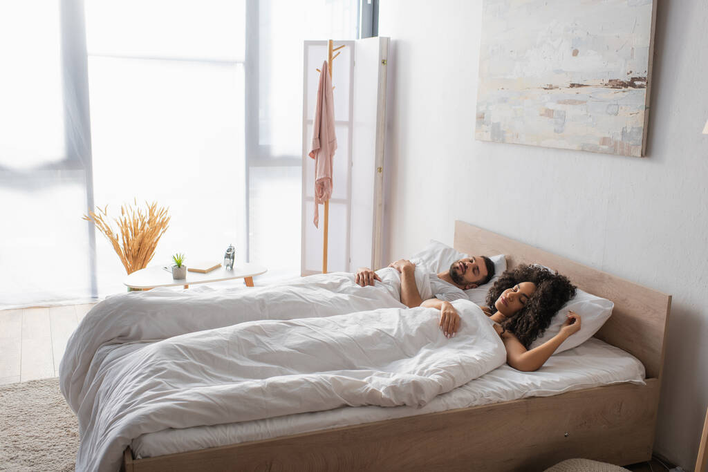 casal multiétnico dormindo juntos na cama - Foto, Imagem
