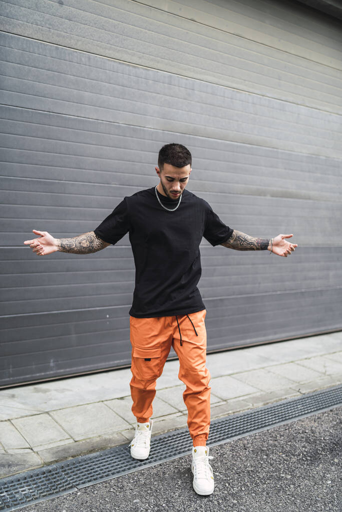 Un uomo alla moda spagnolo con tatuaggi in posa per strada - Foto, immagini
