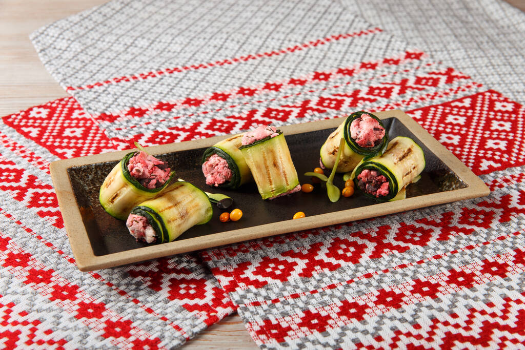 Grilled Zucchini rolls with homemade cheese and dried beetroot served on napkin with national belorussian ornament - Photo, Image