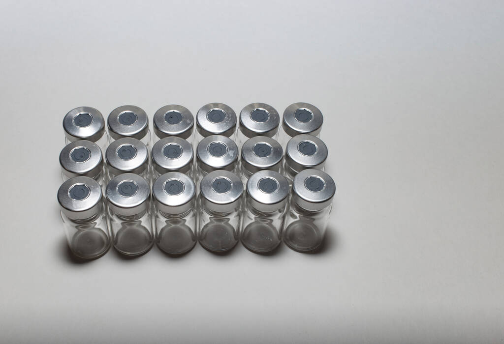 Ampollas médicas vacías después de las inyecciones durante la vacunación y prevención durante una pandemia en un primer plano de fondo blanco. enfoque borroso - Foto, Imagen