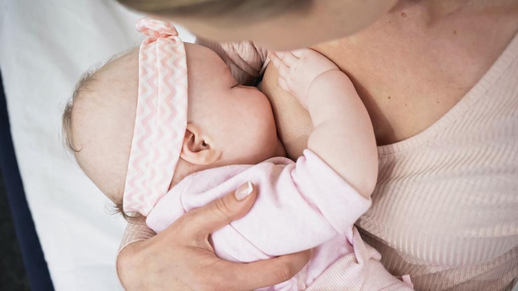 Mutter füttert mit Brust Baby Mädchen in Stirnband mit Schleife - Foto, Bild