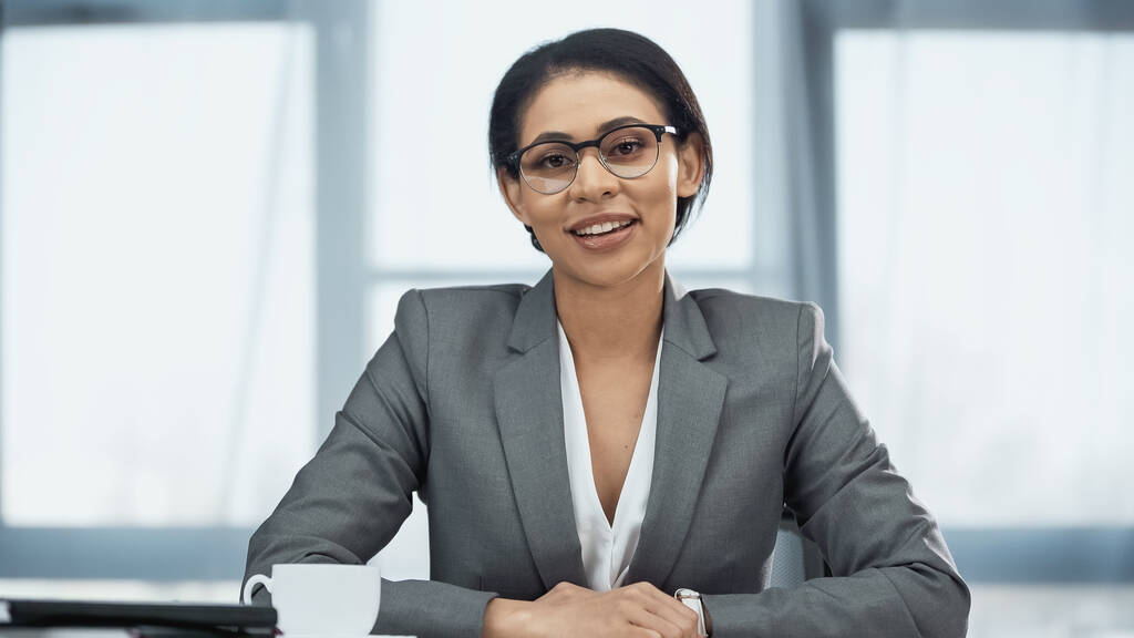 улыбающаяся американская бизнесвумен в очках, смотрящая в камеру - Фото, изображение