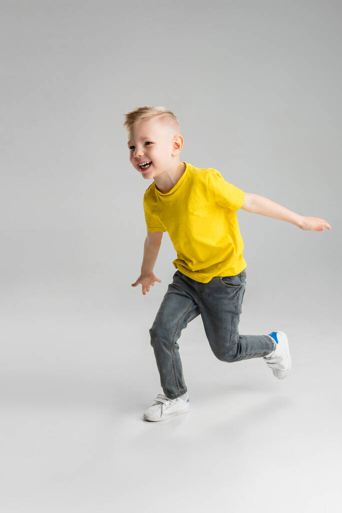 Χαρούμενο αγόρι απομονωμένο σε λευκό φόντο στούντιο. Φαίνεται χαρούμενος, χαρούμενος, ειλικρινής. Αντιγραφή χώρου. Παιδική ηλικία, εκπαίδευση, τα συναισθήματα έννοια - Φωτογραφία, εικόνα