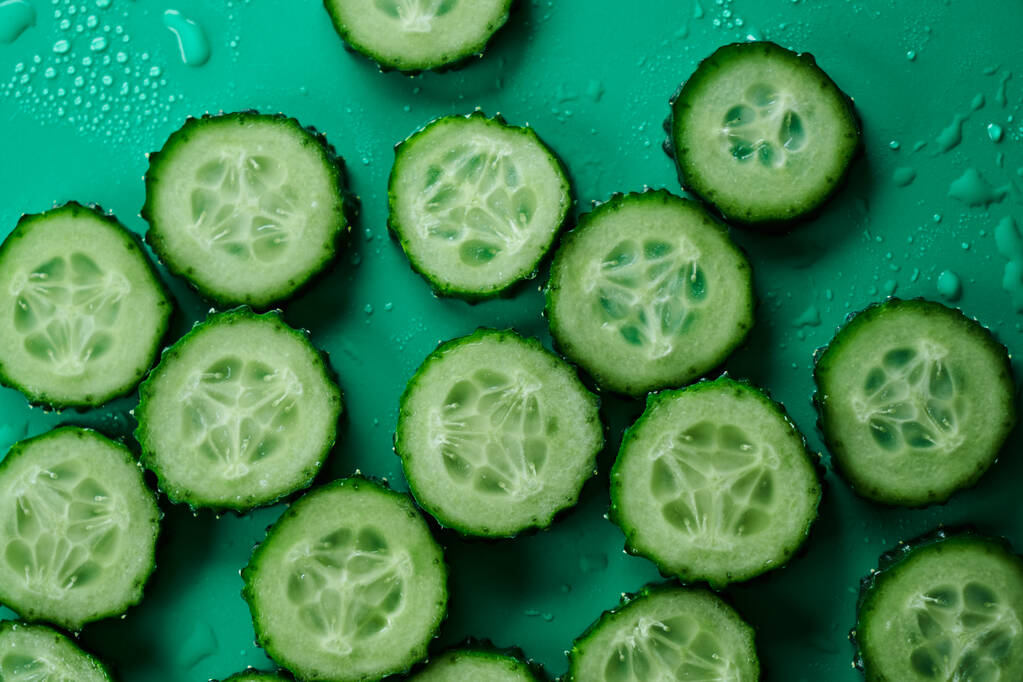 Uborka szeletek minta elszigetelt zöld háttér. Kreatív uborka tapéta, élelmiszer háttér tervezés - Fotó, kép
