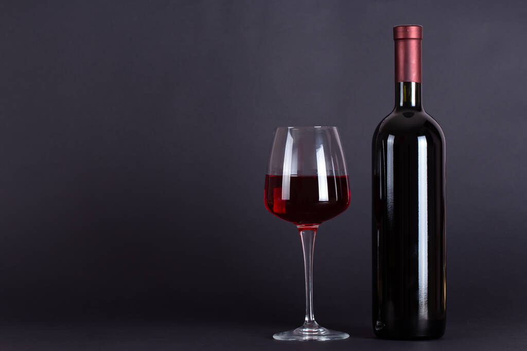 Bottiglia sigillata di vino rosso e vetro su sfondo lilla, con spazio per il testo. Degustazione di vini e cultura del bere. Bevanda alcolica - Foto, immagini