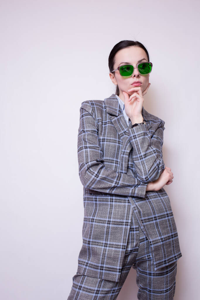 femme en lunettes vertes et costume à carreaux gris - Photo, image