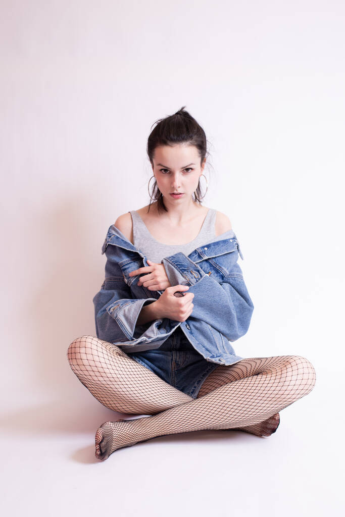 Frau in Jeansjacke und Shorts, auf weißem Studiohintergrund - Foto, Bild