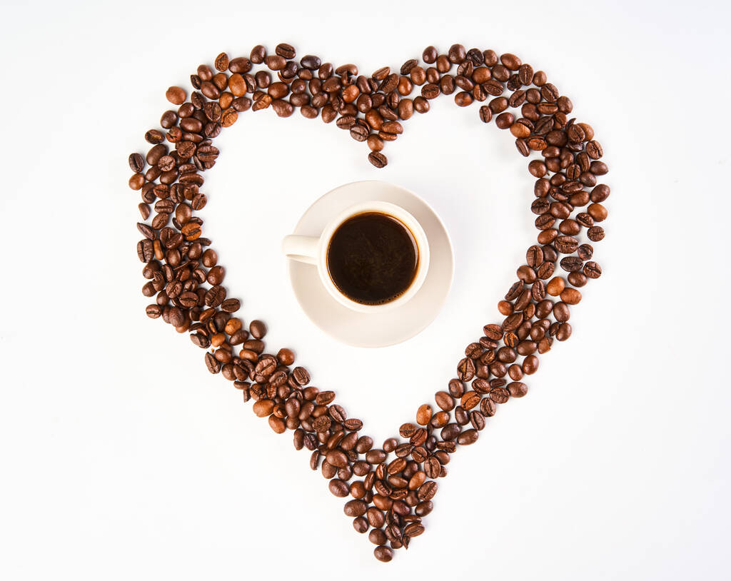 Чашка кави всередині серця з кавових зерен, ізольована на білому тлі
 - Фото, зображення