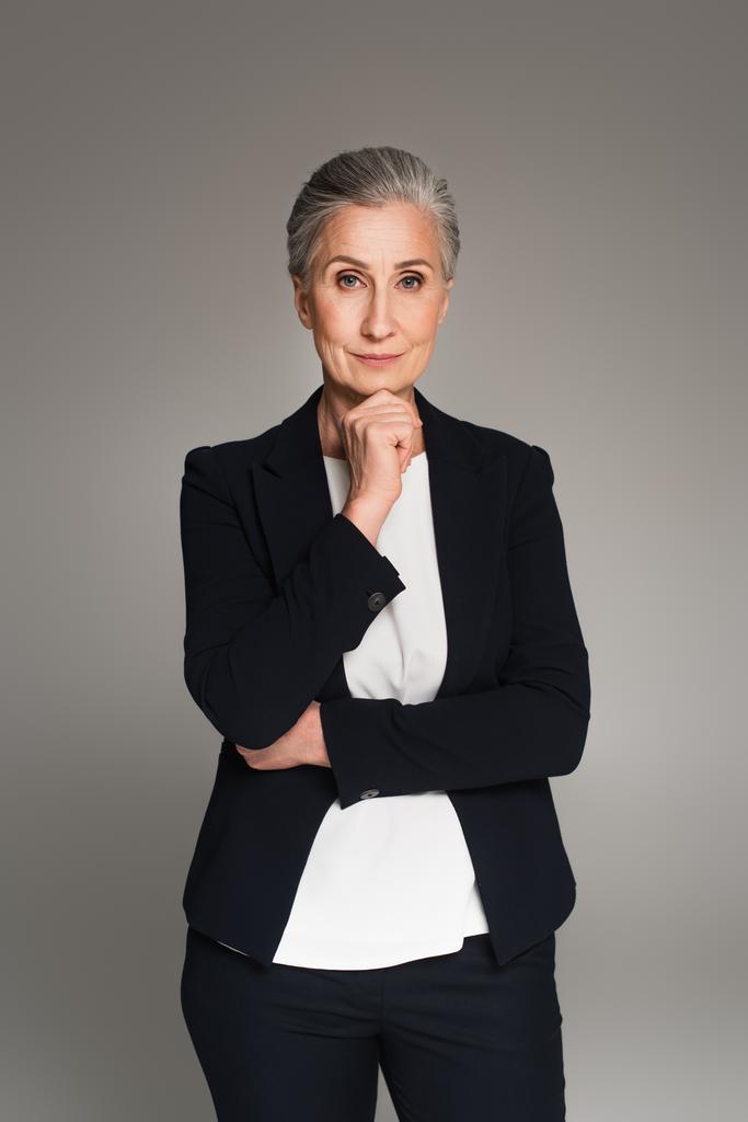 Mature businesswoman looking at camera isolated on grey  - Photo, Image