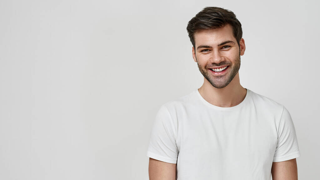 Щасливий чоловік у білій футболці дивиться на камеру
 - Фото, зображення