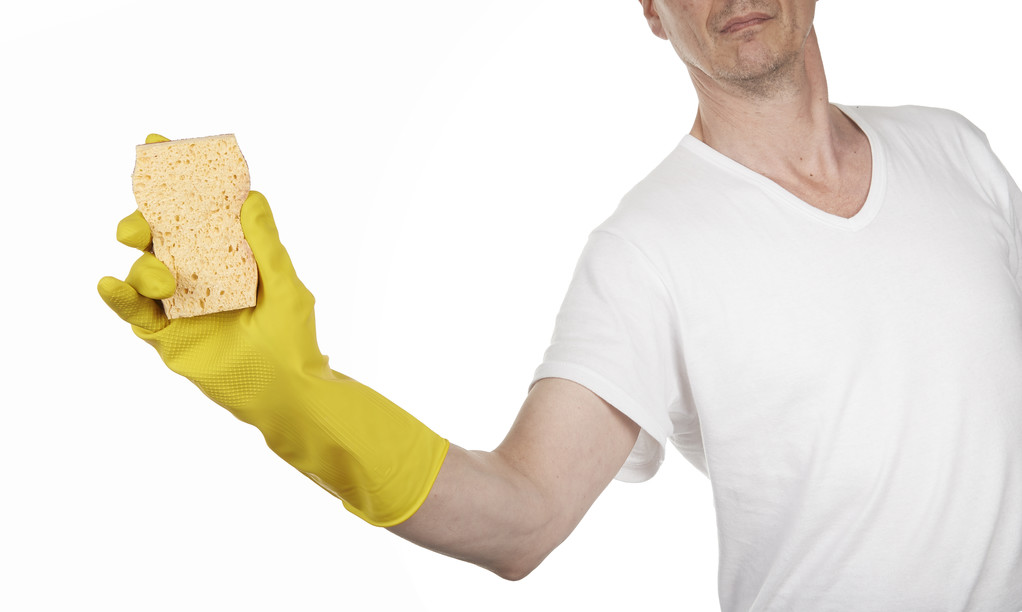 ένα κίτρινο καθαρισμού γάντι με ένα σφουγγάρι - Φωτογραφία, εικόνα