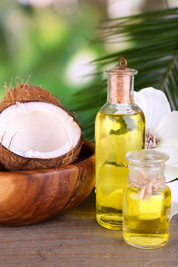 Cocos y aceite de coco sobre mesa de madera, sobre fondo natural
 - Foto, Imagen