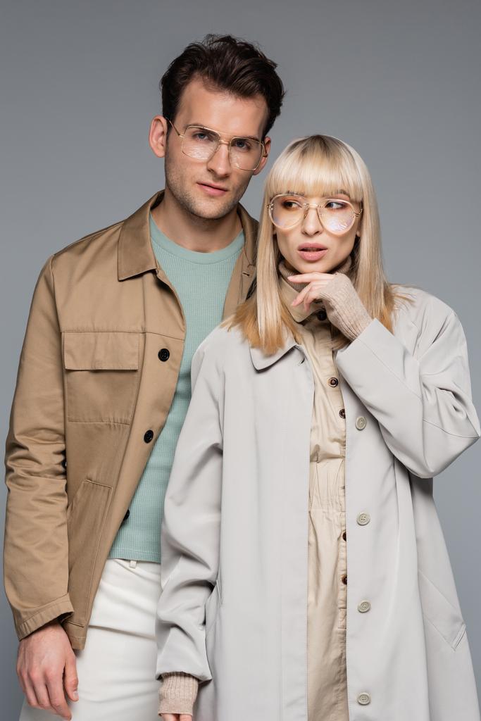 pareja de moda en gafas posando aisladas en gris - Foto, imagen