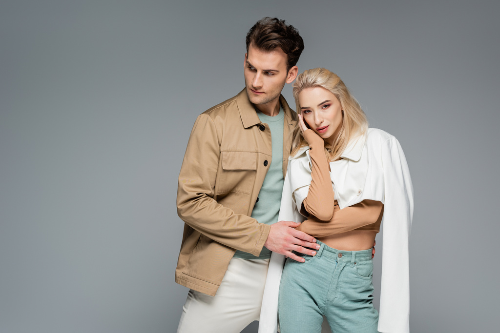Models in Hosen und Jacken posieren vereinzelt auf grau - Foto, Bild