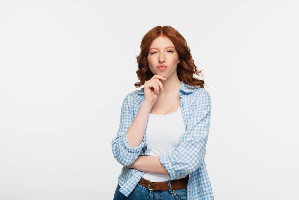 rothaarige junge Frau in blau kariertem Hemd schmollen Lippen isoliert auf weiß - Foto, Bild